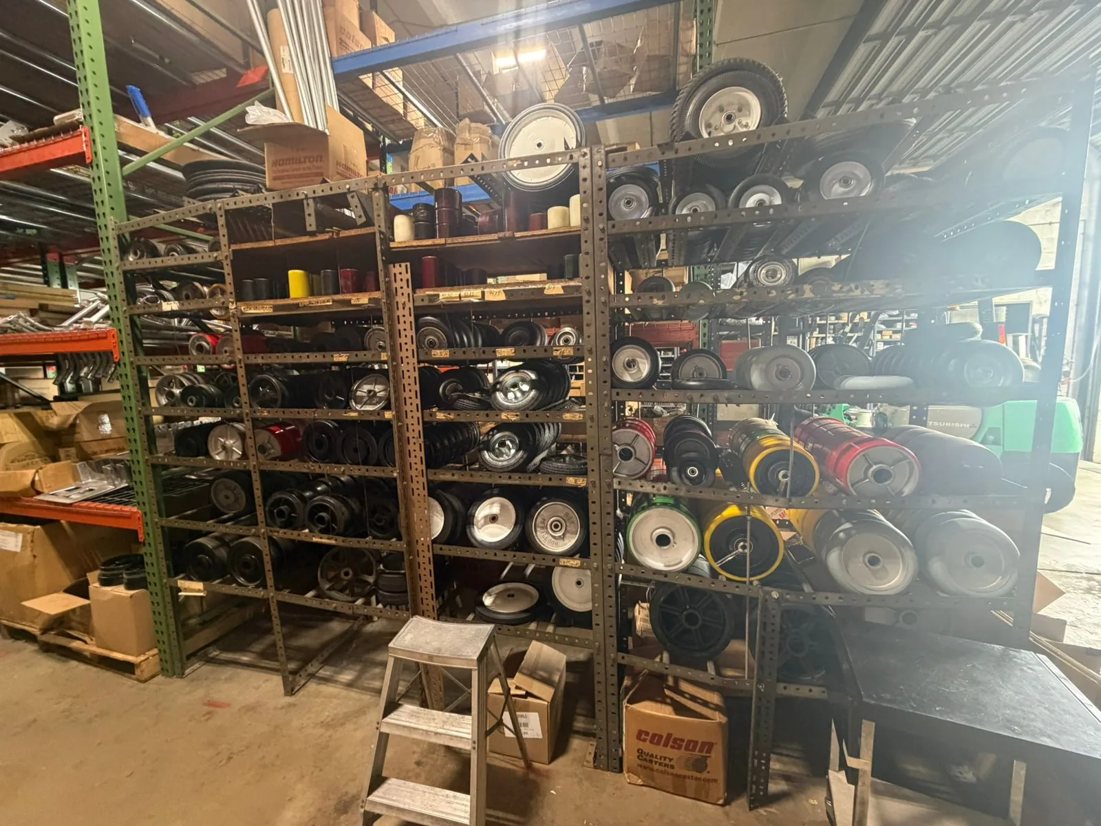 DECO legacy caster wheels stocked on warehouse racks at Douglas Equipment Miami — 1,546 part numbers still supplied